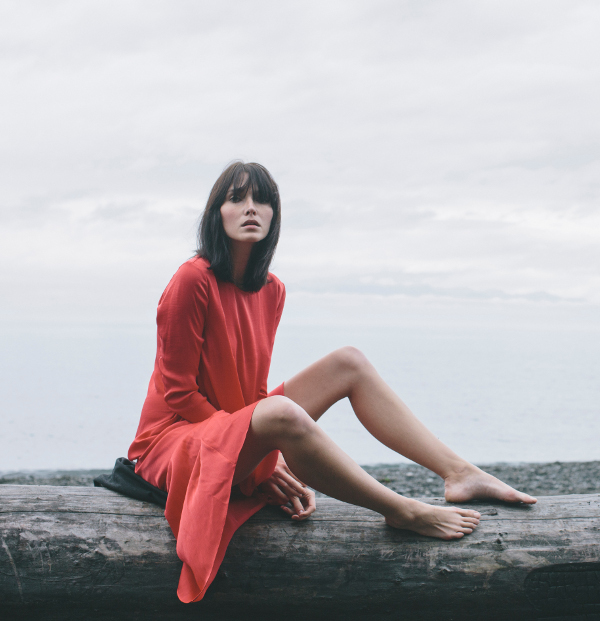 Woman wearing a red dress like silk enhanced with HeiQ Real Silk textile technology