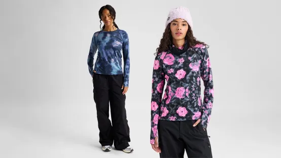 The image features two models wearing Burton jackets incorporating HeiQ technologies, designed to enhance performance, comfort and protection. The garments combine advanced textile technologies with functional design, making them suitable for snowboarding and outdoor activities.
